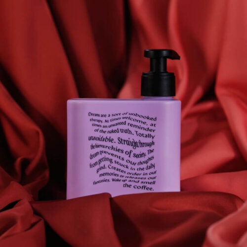 Lila flaska med Meyenberg Lavender and Sandalwood handtvål på röd tygbakgrund.