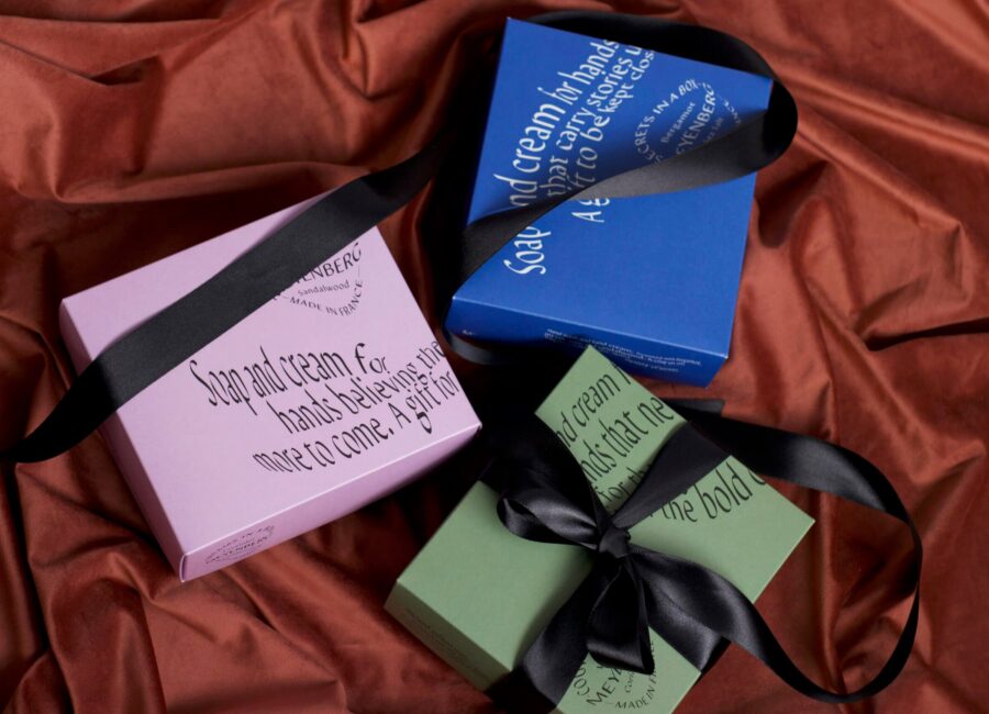 The Gift Set Collection, featuring all three gift sets on red velvet fabric with a black silk ribbon wrapped around them