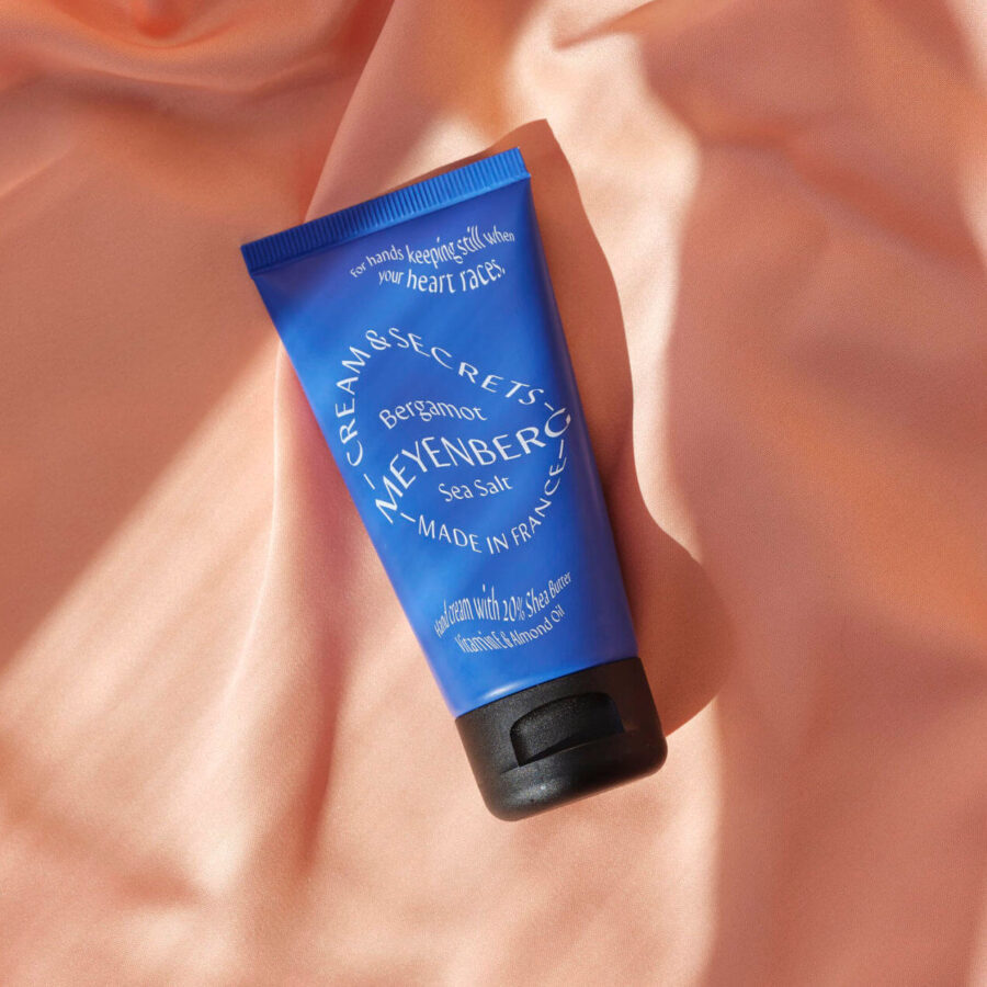 Creams and Secrets handkräm i doften Bergamot & Sea Salt mot persikofärgat tyg.